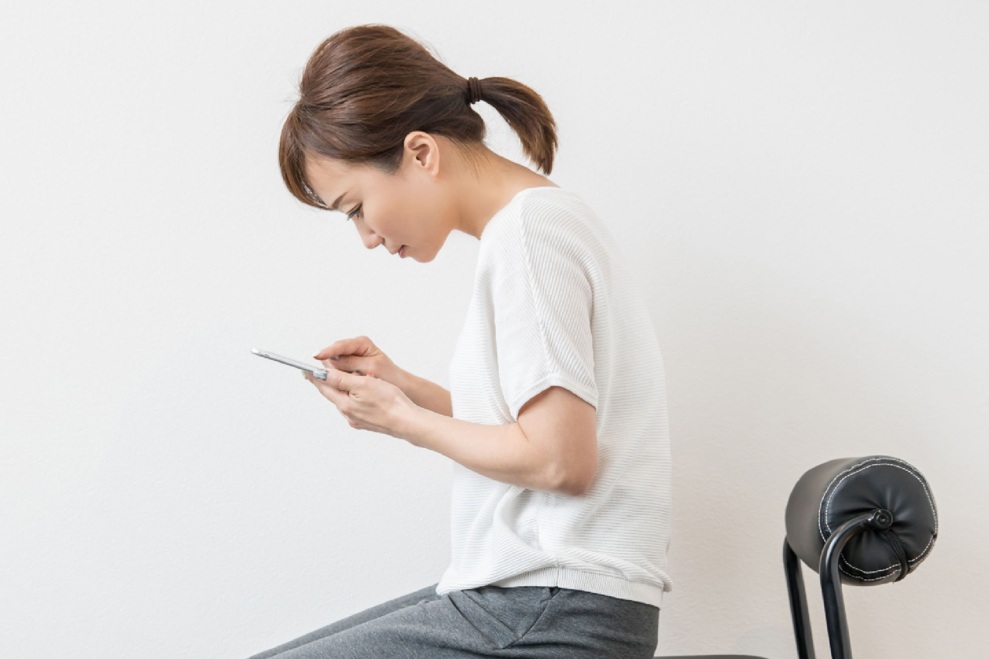 長浜市でスマホ操作で猫背になる女性